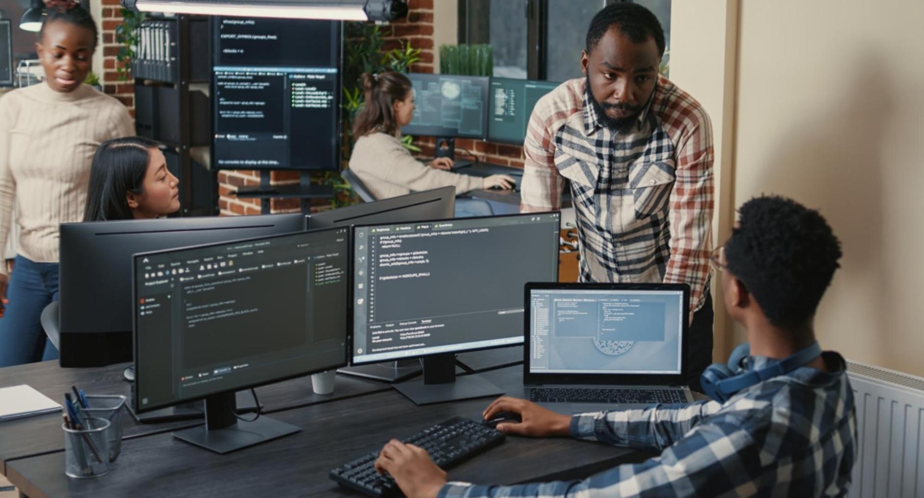 Modern design workspace with multiple monitors showing UI mockups and design tools